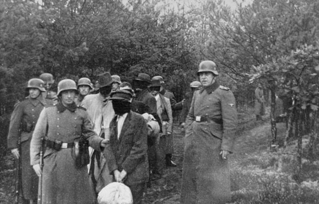 Polish civilians wearing blindfolds photographed just before their execution by German soldiers in Palmiry forest, 1940