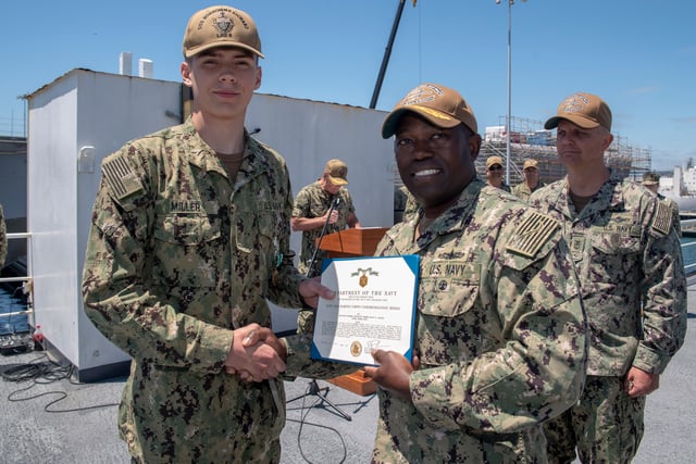 A sailor receives a certificate of the award in 2019