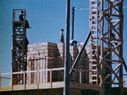 Men stack crates of high explosives for the 100-ton test