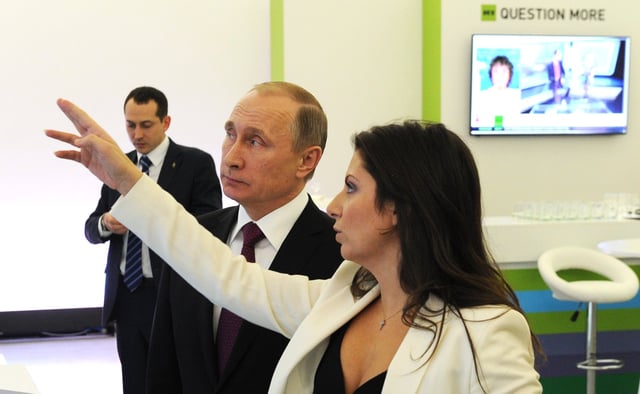 President Putin with Margarita Simonyan in front of RT's "Question more" slogan (2015)
