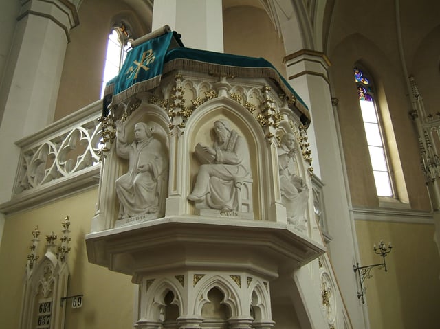 Key figures of the Protestant Reformation: Martin Luther and John Calvin depicted on a church pulpit. These reformers emphasised preaching and made it a centerpiece of worship.