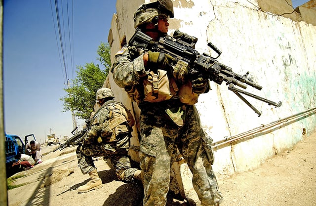 U.S. soldiers from the 6th Infantry Regiment taking up positions on a street corner during a foot patrol in Ramadi, Iraq