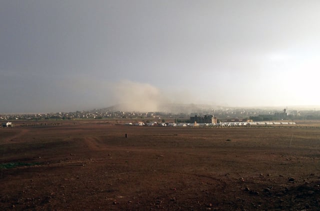 Kobanî during the bombardment of ISIL targets by US-led forces. Photo taken from Turkish-Syrian border at Suruç,Suruc, Turkey showing refugee camp in the middle distance (October 2014)