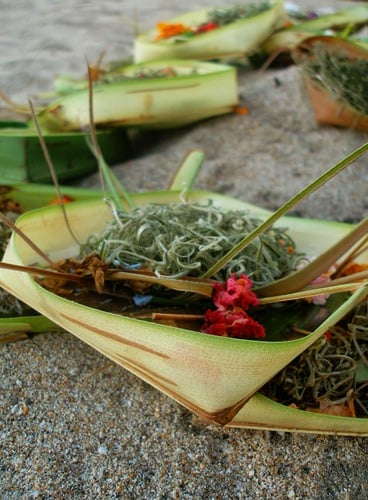 A canang, an offering of flowers, rice, and incense in woven coconut leaves from Bali, Indonesia