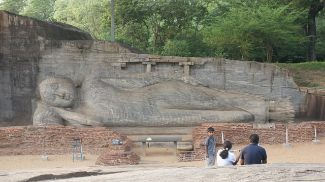 Reclining Buddha at Gal Vihara, Sri Lanka. The image house that originally enclosed the remains can be seen.