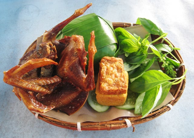 Fried pigeon with nasi timbel (banana leaf wrapped rice), tempeh, tofu, and vegetables, Sundanese cuisine, Indonesia