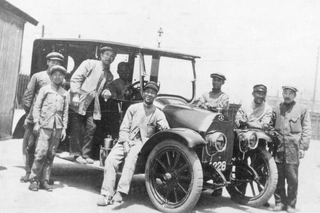 Workers at Mitsubishi Shipbuilding Co., Ltd alongside one of the prototype Mitsubishi Model A automobiles.