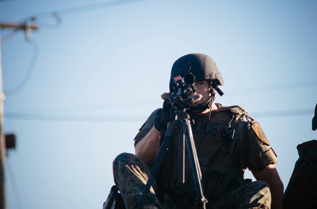 Police sharpshooter atop a SWAT vehicle during protests at Ferguson