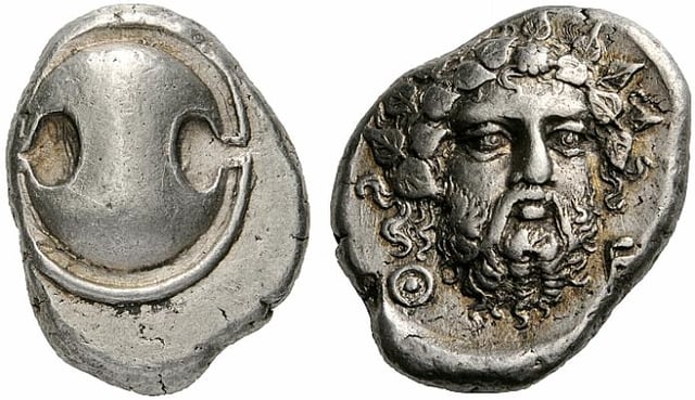Silver stater of Thebes (405-395 BC). Obverse: Boeotian shield, reverse: Head of bearded Dionysus.