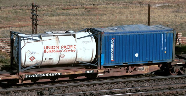 A spine car with a 20 ft tank container and an open-top 20 ft container with canvas cover