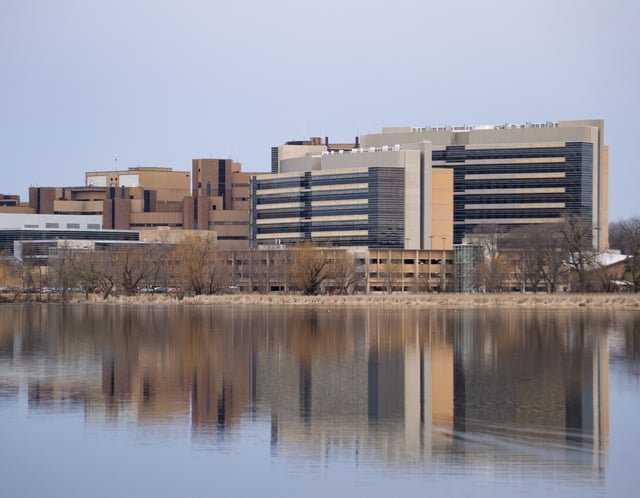 A view of UW Health University Hospital, the Health Sciences Learning Center (HSLC), and the Wisconsin Institutes for Medical Research rising above Lake Mendota, on the western edge of the UW–Madison campus. The University of Wisconsin School of Medicine and Public Health, housed in the HSLC, accounts for 40% of UW–Madison's research grants
