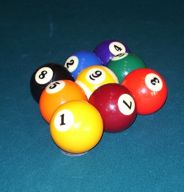 One of many correct nine-ball racks: the 1 ball at the apex centered over the foot spot, the 9 ball at center, the other balls placed randomly, and all balls touching.