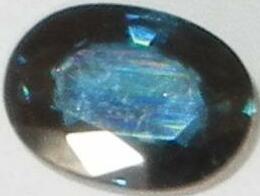 Dark blue sapphire, probably of Australian origin, showing the brilliant surface luster typical of faceted corundum gemstones.