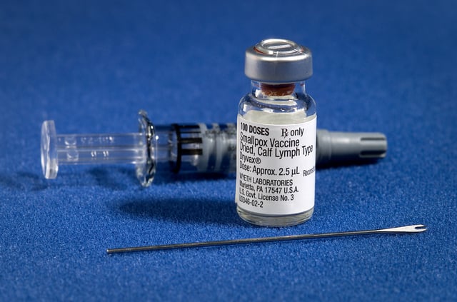 Components of a modern smallpox vaccination kit including the diluent, a vial of Dryvax vaccinia vaccine, and a bifurcated needle.