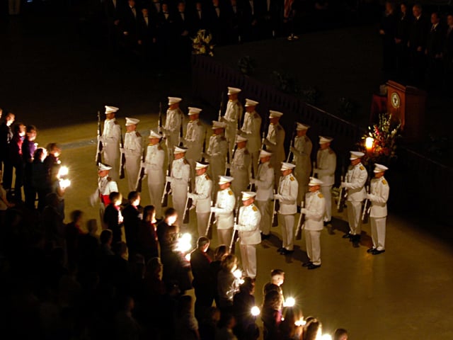 The Ross Volunteers perform a rifleman's salute as candles are lit for the deceased at the 2007 Aggie Muster at Reed Arena.