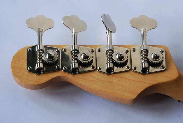 Tuning machines (with spiral metal worm gears) are mounted on the back of the headstock on the bass guitar neck