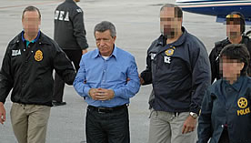 DEA agents escort Colombian drug lord Miguel Rodríguez Orejuela after being extradited to the United States in 2005