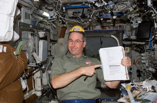 Flight Day 4 (July 30, 2005) NASA image from the STS-114 Space Shuttle mission with the April 2004 issue of Men's Journal laying to astronaut Stephen Robinson's left side.