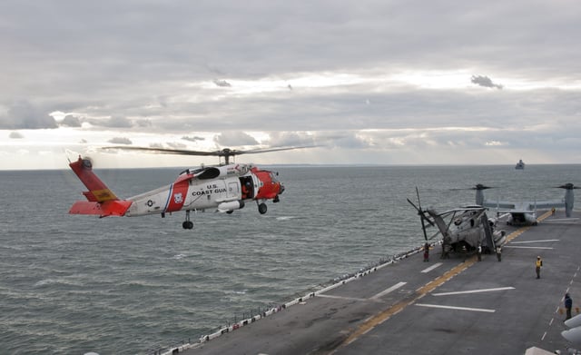 A U.S. Coast Guard helicopter prepares to land on the flight deck of the amphibious assault ship USS Wasp (LHD-1)