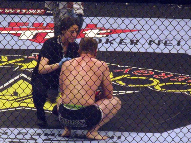 A ring-side doctor attends to a fighter following a loss.
