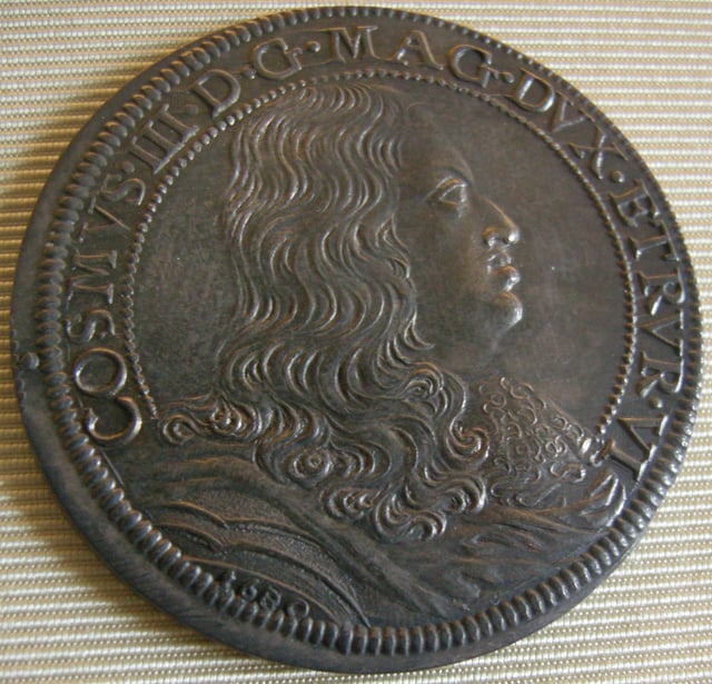 A contemporary piastra bearing the effigy of Cosimo III. Latin inscription: COSMVS III D[EI] G[RATIA] MAG[NVS] DVX ETRVR[AE]. "Cosimo III, by the Grace of God, Grand Duke of Etruria (Tuscany)"