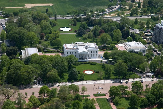 Aerial view of the White House complex, from north. In the foreground is Pennsylvania Avenue, closed to traffic. Center: Executive Residence (1792–1800) with North Portico (1829) facing; left: East Wing (1942);  right: West Wing (1901), with the Oval Office (1909) at its southeast corner