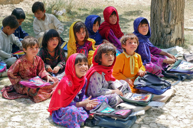 School children sitting in the shade of an orchard in Bamozai, near Gardez, Paktya Province, Afghanistan