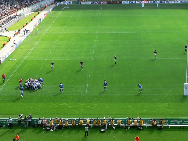 The forwards are in the scrum while the backs are lined up across the field.