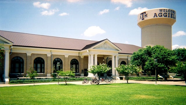 Sbisa Dining Hall and central utility plant water tower sporting the greeting, "Welcome to Aggieland"