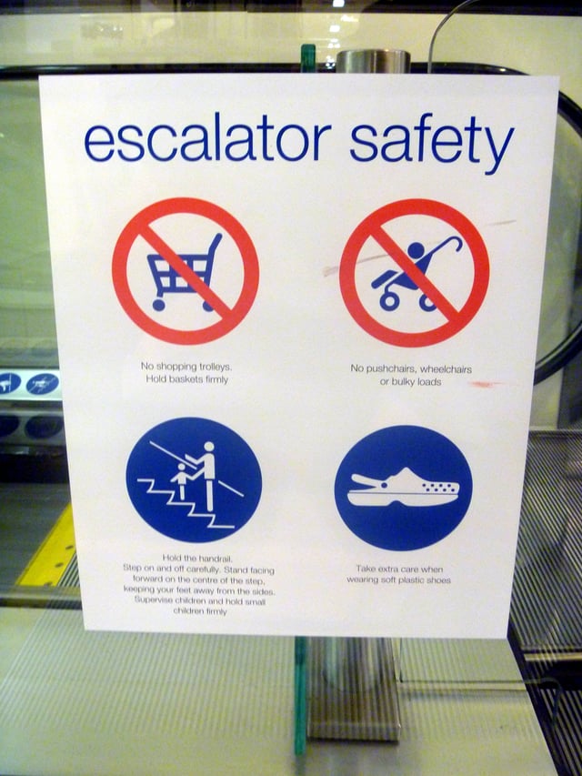 Escalator safety sign warns: Take extra care when wearing soft plastic shoes