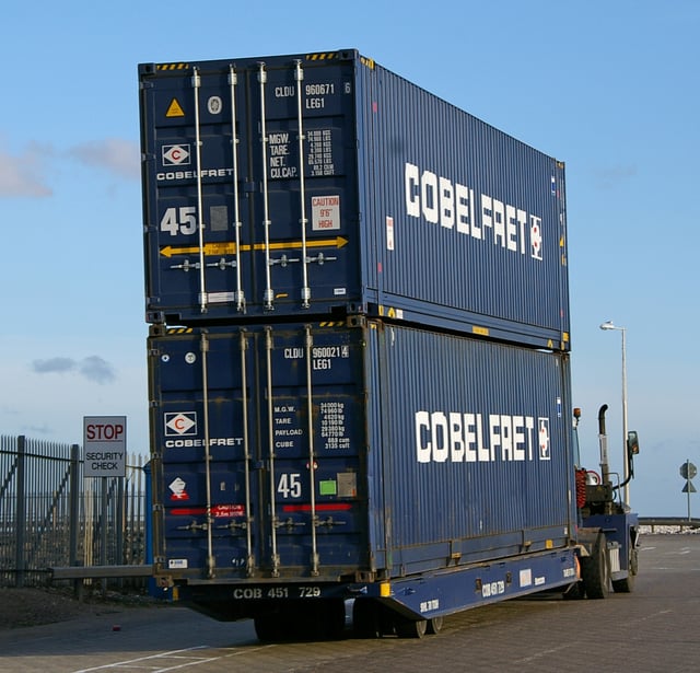 Two 45-foot 'High-cube' containers on a roll-on/roll-off (RoRo) tractor. The 9 ft 6 in height of the boxes is identified by diagonal yellow and black markings on the top corners of the container