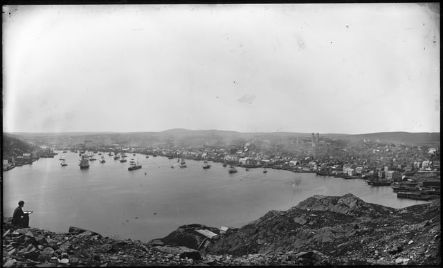 Photograph of an artist sketching St. John's harbour and skyline, c. 1910