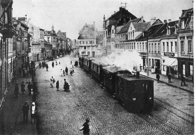 A German steam tram engine from the Cologne-Bonn railway, pulling a train through Brühl marketplace, around 1900