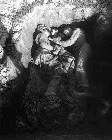 Two US Marines share a foxhole with an Okinawan war orphan in April 1945.