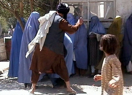 Member of the Taliban's religious police beating an Afghan woman in Kabul on August 26, 2001. State violence against women is a form of discrimination.