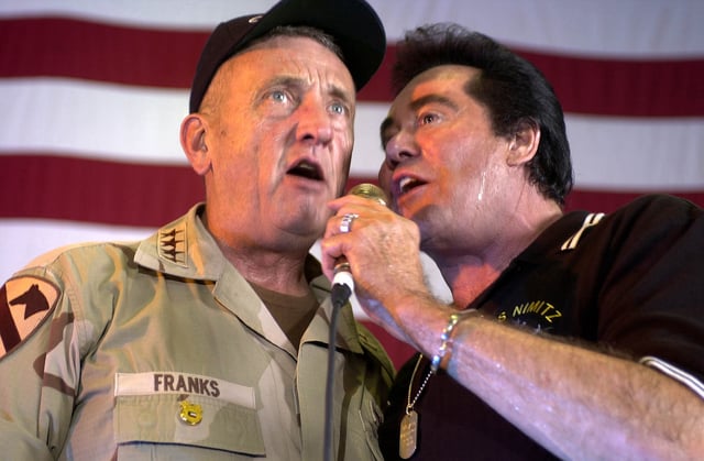 Gen. Tommy Franks, Commander, U.S. Forces Central Command (CENTCOM) sings a duet with Wayne Newton aboard the USS Nimitz during a USO show. At the time, the USS Nimitz was deployed to the Persian Gulf in support of Operation Iraqi Freedom. June, 2003.