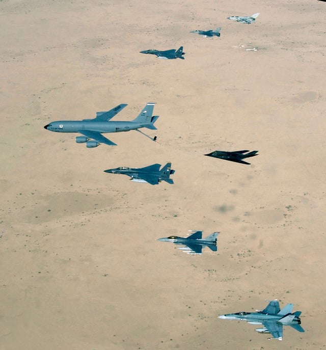 Aircraft of the USAF 379th Air Expeditionary Wing and UK and Australian counterparts stationed together at Al Udeid Air Base, Qatar, in southwest Asia, fly over the desert on 14 April 2003. Aircraft include KC-135 Stratotanker, F-15E Strike Eagle, F-117 Nighthawk, F-16CJ Falcon, British GR-4 Tornado, and Australian F/A-18 Hornet