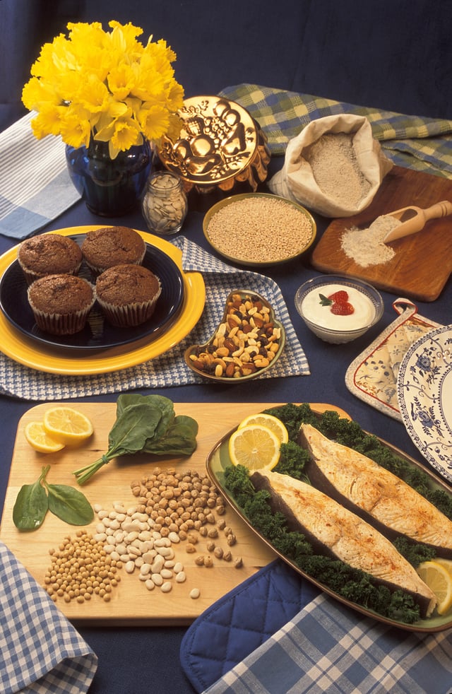 Examples of food sources of magnesium (clockwise from top left): bran muffins, pumpkin seeds, barley, buckwheat flour, low-fat vanilla yogurt, trail mix, halibut steaks, garbanzo beans, lima beans, soybeans, and spinach