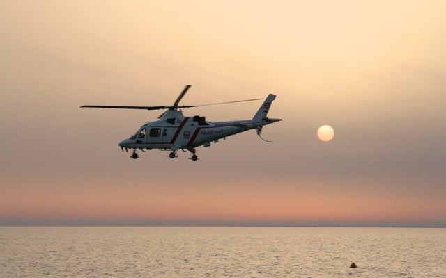 Dubai Police helicopter flying at sunset.