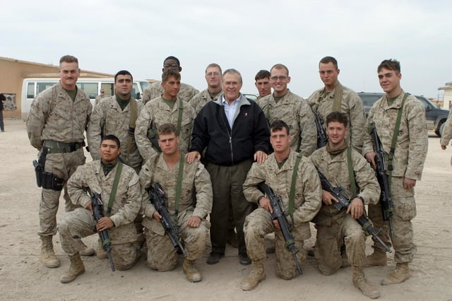 Rumsfeld poses with Marines during one of his trips to Camp Fallujah, Iraq, on Christmas Eve 2004.