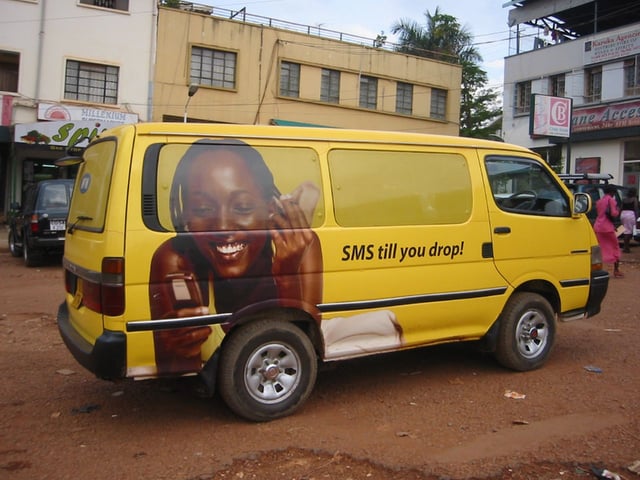 An advertisement for a mobile phone carrier on a van in Kampala.