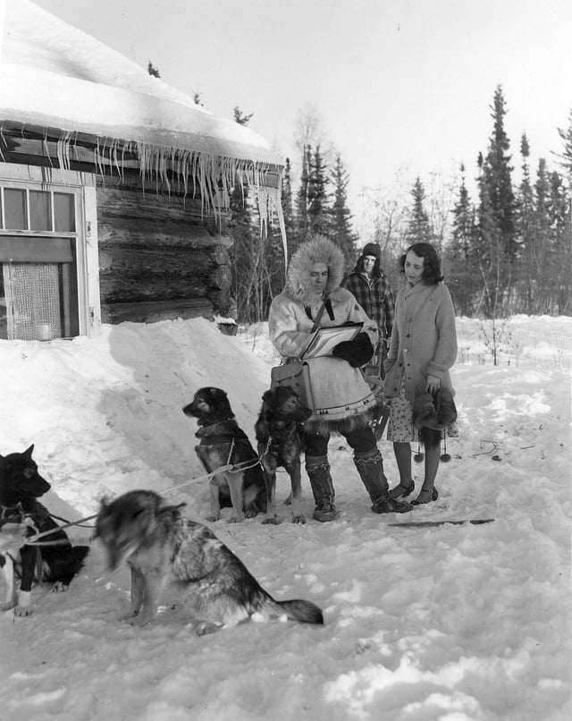 This 1940 Census publicity photo shows a census worker in Fairbanks, Alaska. The dog musher remains out of earshot to maintain confidentiality.
