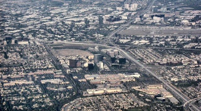 Aerial view of an edge city: Irvine Business Complex (top), John Wayne Airport runway (upper center), South Coast Metro buildings (lower center) and below, the South Coast Plaza mall