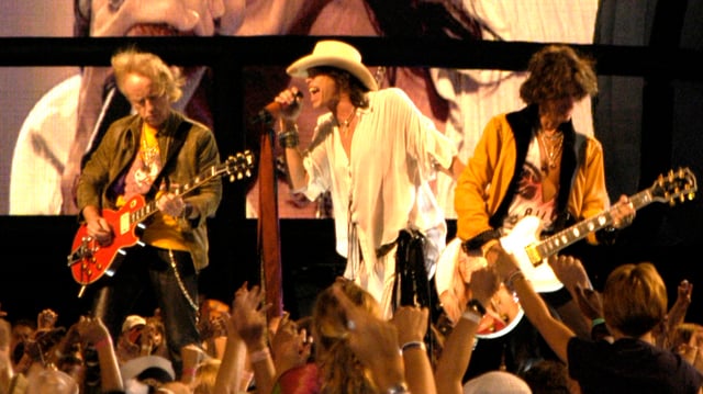 Brad Whitford, Steven Tyler, and Joe Perry of Aerosmith performing at the NFL Kickoff in Washington, DC on September 4, 2003