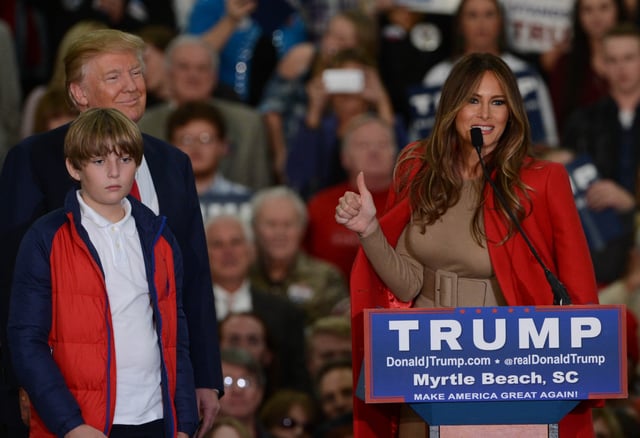 Melania gives the thumbs up at a campaign event with her husband Donald and son Barron, November 2015