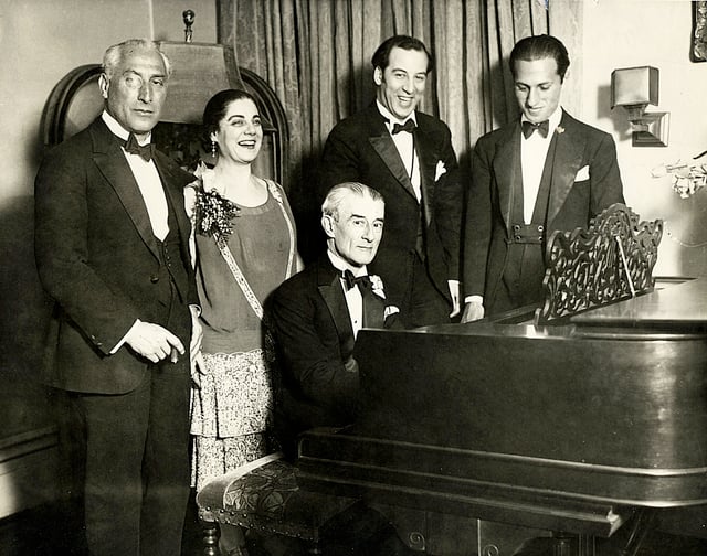 Birthday party honoring French pianist Maurice Ravel in 1928. From left to right: conductor Oscar Fried, singer Eva Gauthier, Maurice Ravel (at piano), composer-conductor Manoah Leide-Tedesco, and composer George Gershwin.