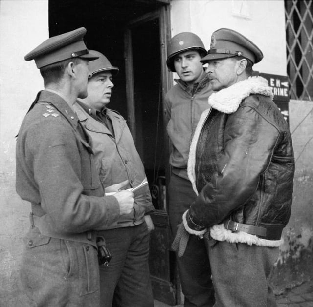 General Sir Harold Alexander, (right, wearing Irvin jacket) commanding 15th Army Group, talks to American and British officers in Anzio, 14 February 1944.