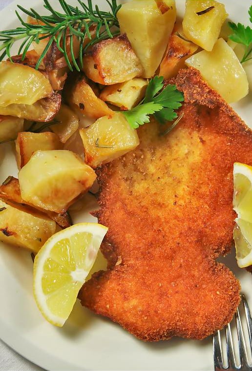 A traditional "Cotoletta alla milanese (Milanese-style cutlet)" served with potatoes.