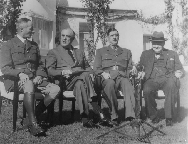 Free French Generals Henri Giraud (left) and Charles de Gaulle sit down after shaking hands in the presence of Franklin Roosevelt and Winston Churchill at the Casablanca Conference, on 14 January 1943.
