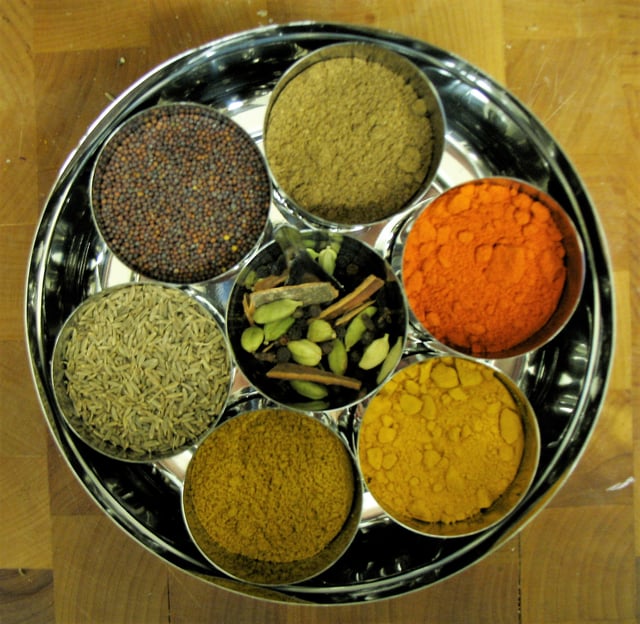 A group of Indian spices and herbs in bowls